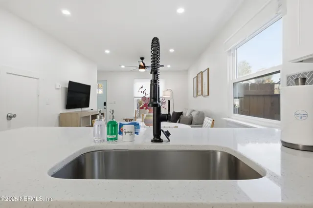 a kitchen with a sink and a flat screen tv