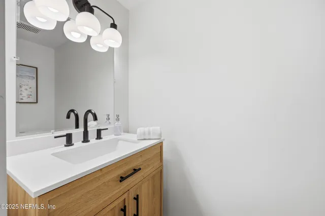 a bathroom with a sink vanity and a mirror