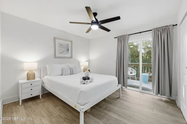 a white bed sitting in a bedroom next to a window