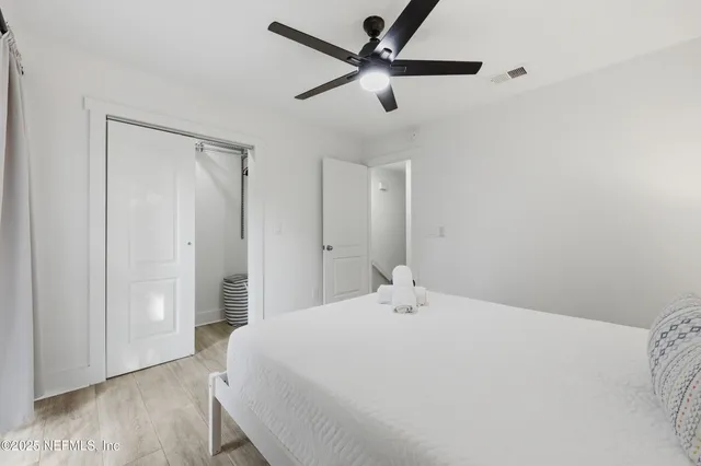 a bedroom with a bed and a ceiling fan