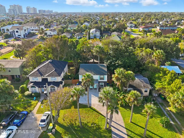 an aerial view of residential houses with outdoor space and trees