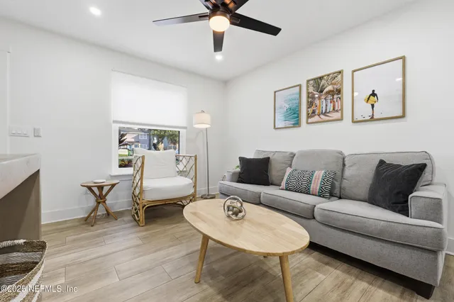 a living room with furniture and a wooden floor