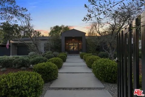 a front view of a house with a garden