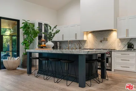 a kitchen with a table chairs sink and cabinets