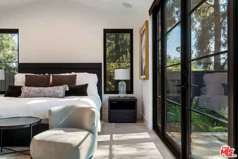 a bedroom with a bed and a balcony view