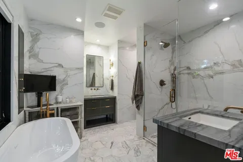 a bathroom with a tub sink and mirror
