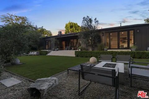 a view of a house with backyard and sitting area