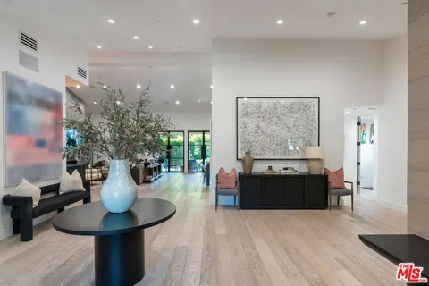 a living room with furniture a large window and kitchen view