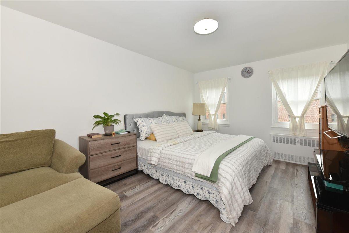 196-65 69th Avenue, Unit 1 Queens, NY 11365 - Photo 16 of 24 Bedroom featuring radiator heating unit and wood finished floors