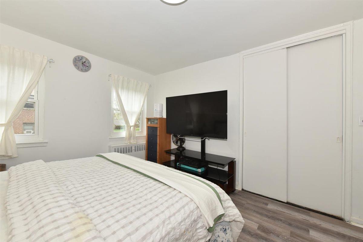 196-65 69th Avenue, Unit 1 Queens, NY 11365 - Photo 18 of 24 Bedroom with a closet, radiator, and wood finished floors