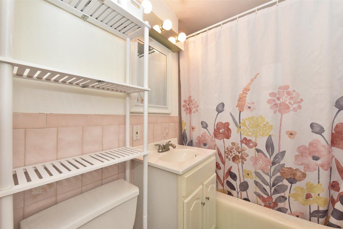 196-65 69th Avenue, Unit 1 Queens, NY 11365 - Photo 21 of 24 Bathroom with vanity, toilet, and decorative backsplash