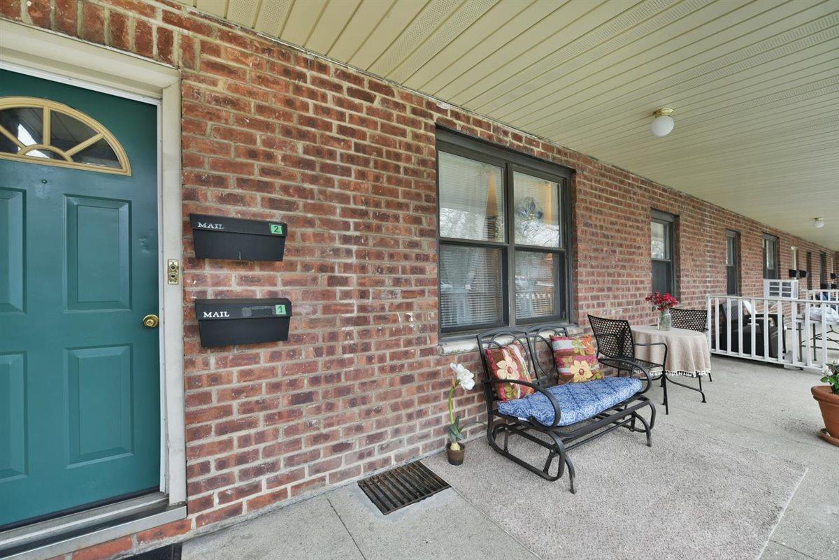 196-65 69th Avenue, Unit 1 Queens, NY 11365 - Photo 3 of 24 Doorway to property featuring covered porch and brick siding