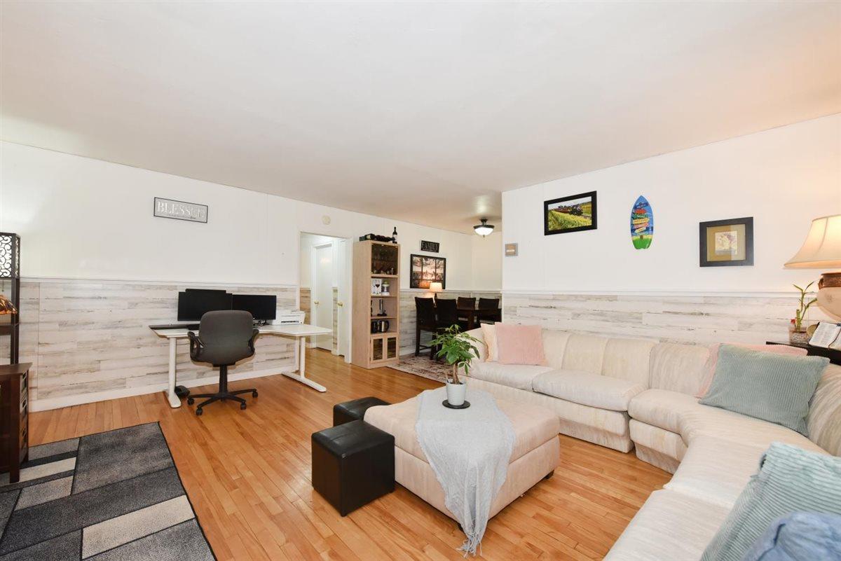 196-65 69th Avenue, Unit 1 Queens, NY 11365 - Photo 6 of 24 Living area featuring wainscoting and wood finished floors