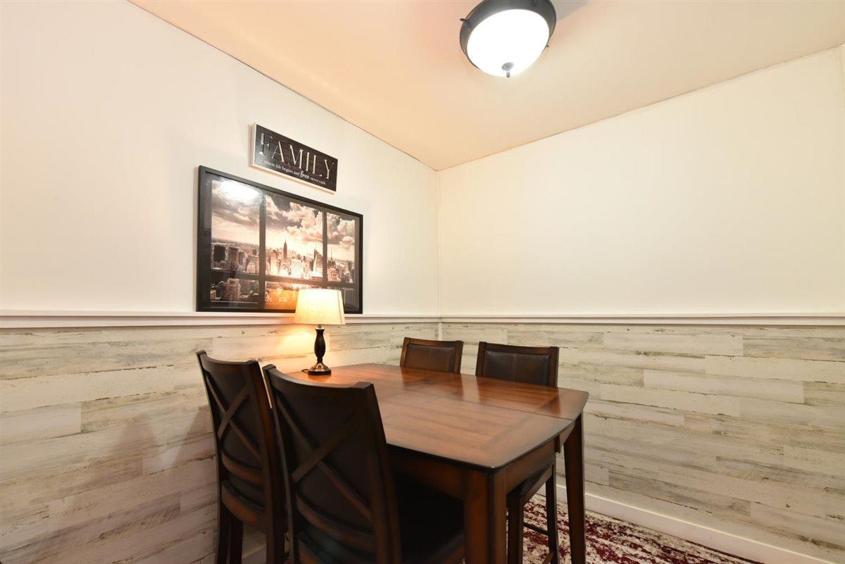 196-65 69th Avenue, Unit 1 Queens, NY 11365 - Photo 10 of 24 Dining area featuring wooden walls and a wainscoted wall