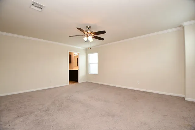 an empty room with chandelier fan and windows