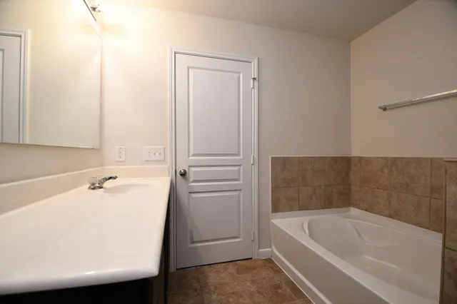 a bathroom with a tub sink and vanity