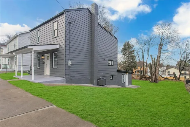 a front view of a house with a garden and yard