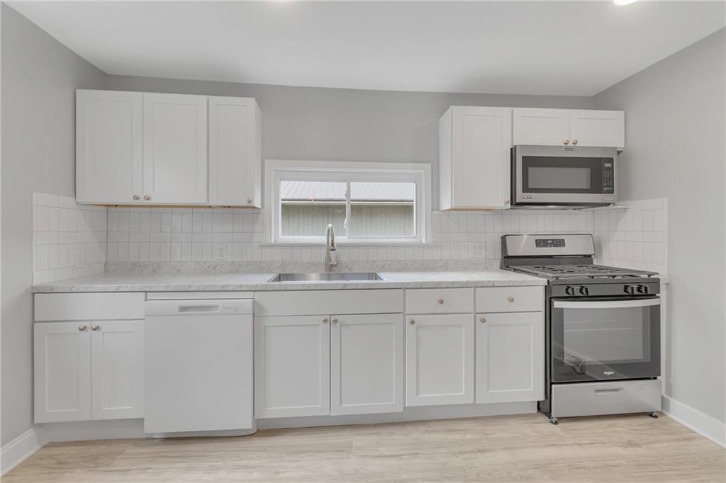 517 Adams Street Rochester, PA 15074 - Photo 6 of 21 a kitchen with stainless steel appliances granite countertop a stove a sink and a microwave