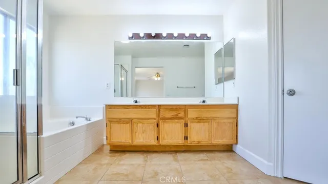 a spacious bathroom with a tub sink and mirror