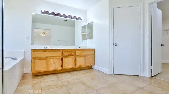 a view of a bathroom with mirror and bathtub