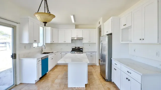 a kitchen with white cabinets and stainless steel appliances