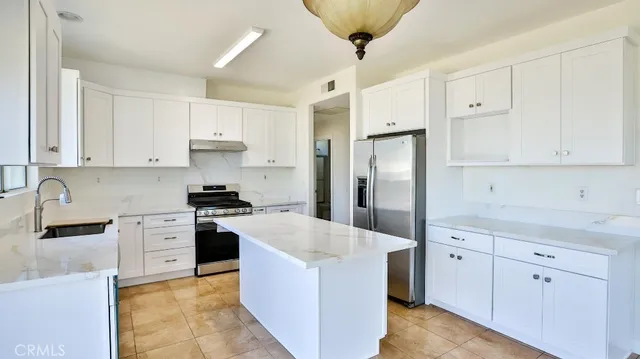 a kitchen with white cabinets and stainless steel appliances