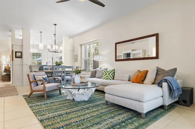 a living room with lots of white furniture and a rug