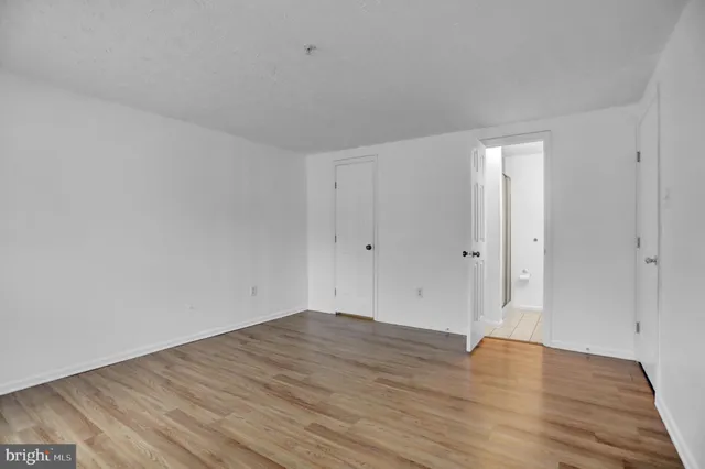 a view of an empty room with wooden floor