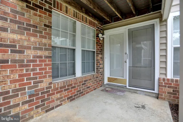 a front view of a building with a garden and trees