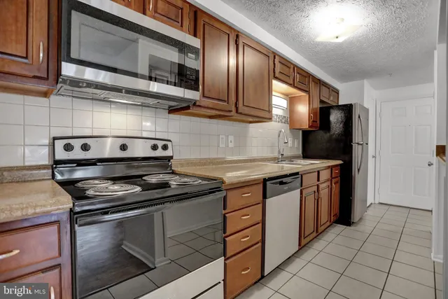 a kitchen with stainless steel appliances granite countertop a stove and a microwave