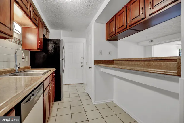a view of kitchen with refrigerator stove microwave and oven