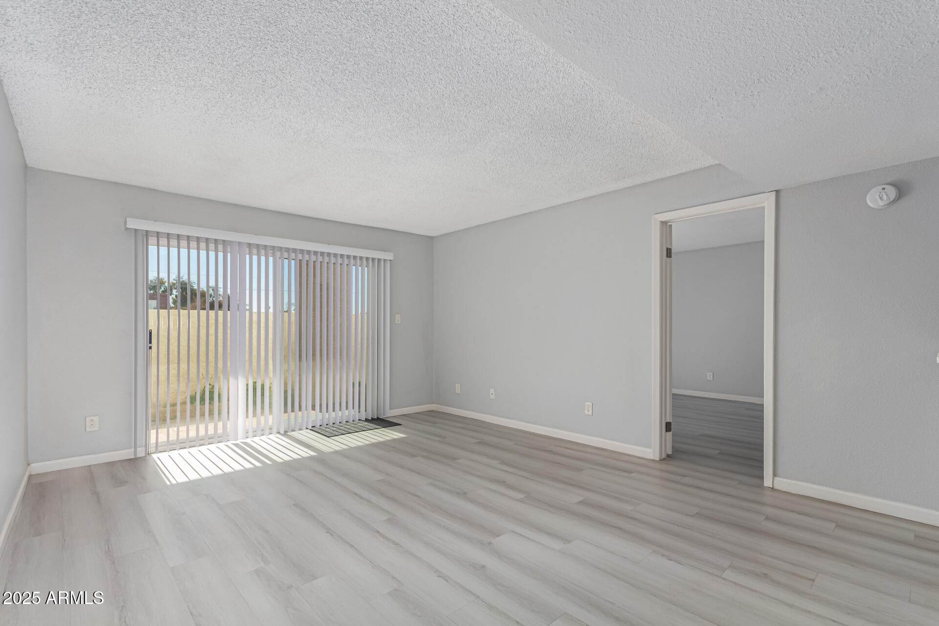4730 West Northern Avenue, Unit 1087 Glendale, AZ 85301 - Photo 7 of 34 an empty room with wooden floor and windows