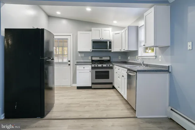 a kitchen with white cabinets and stainless steel appliances