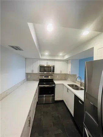 a kitchen with stainless steel appliances a sink stove and refrigerator
