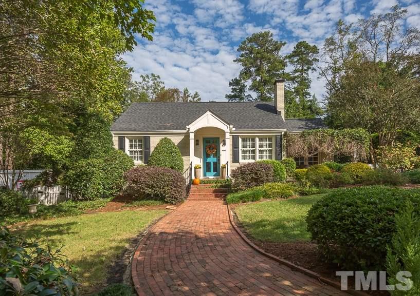 3104 Georgian Terrace Raleigh, NC 27607 - Photo 1 of 25 a front view of a house with a yard and shrubs
