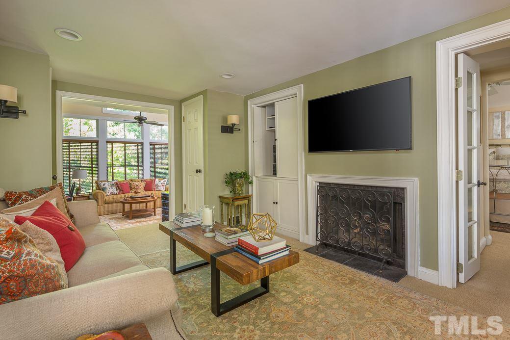3104 Georgian Terrace Raleigh, NC 27607 - Photo 5 of 25 a living room with furniture a flat screen tv and a fireplace