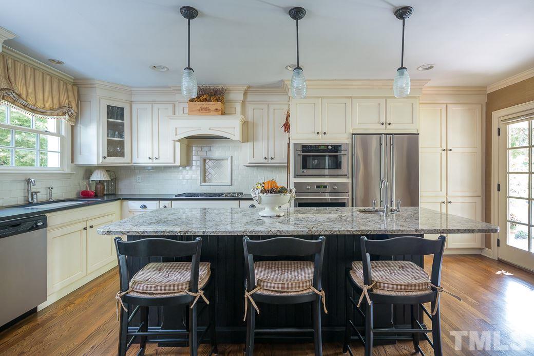 3104 Georgian Terrace Raleigh, NC 27607 - Photo 9 of 25 a kitchen with stainless steel appliances granite countertop a kitchen island a stove a table and chairs