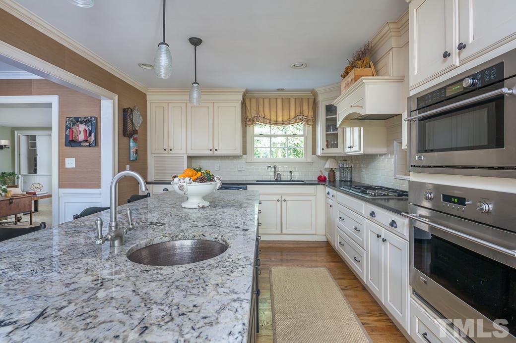 3104 Georgian Terrace Raleigh, NC 27607 - Photo 10 of 25 a kitchen with stainless steel appliances granite countertop a sink a stove top oven a counter space and cabinets