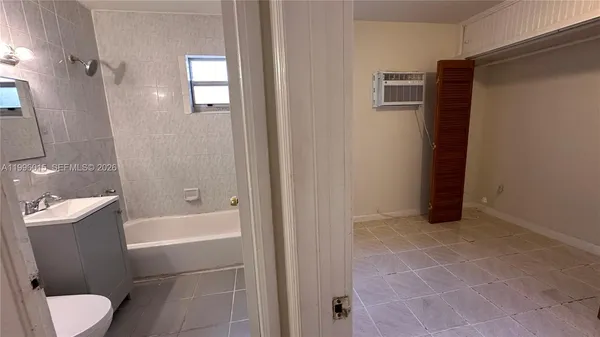 a white toilet sitting next to a bath tub