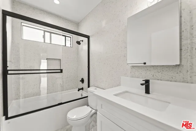 a bathroom with a sink a toilet and a shower