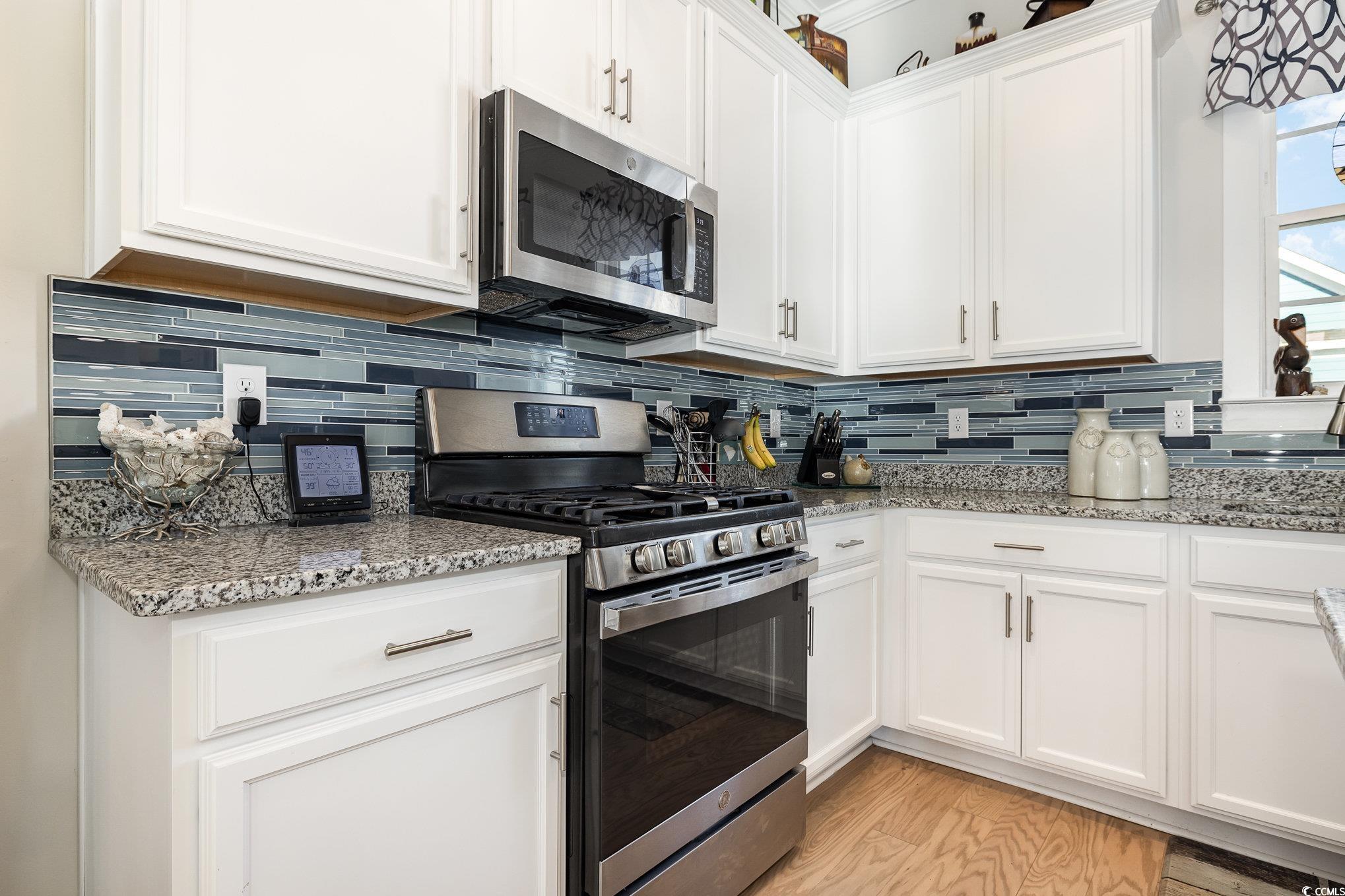 839 Rosa Circle Myrtle Beach, SC 29577 - Photo 12 of 40 Kitchen with light stone countertops, white cabine