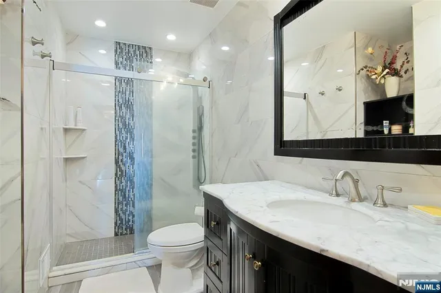 a bathroom with a granite countertop sink toilet and shower