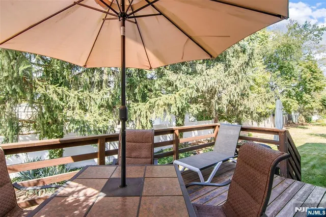 a view of a patio with table and chairs under an umbrella