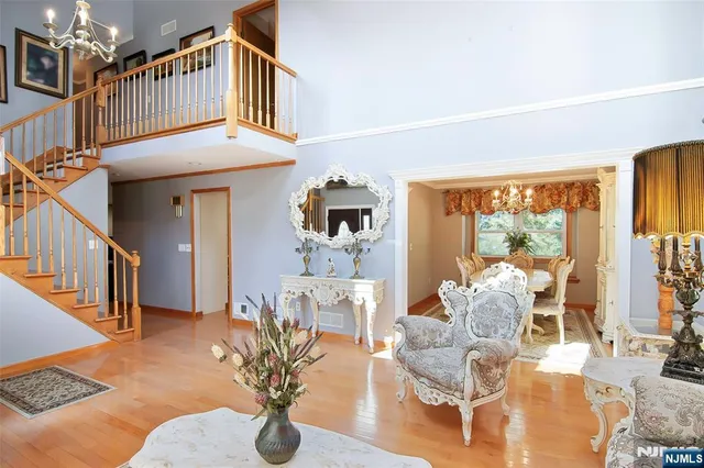 a living room with couches a dining table and a chandelier with outer view