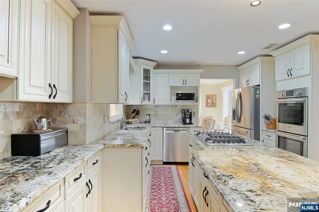 a large kitchen with kitchen island granite countertop a sink stove and refrigerator
