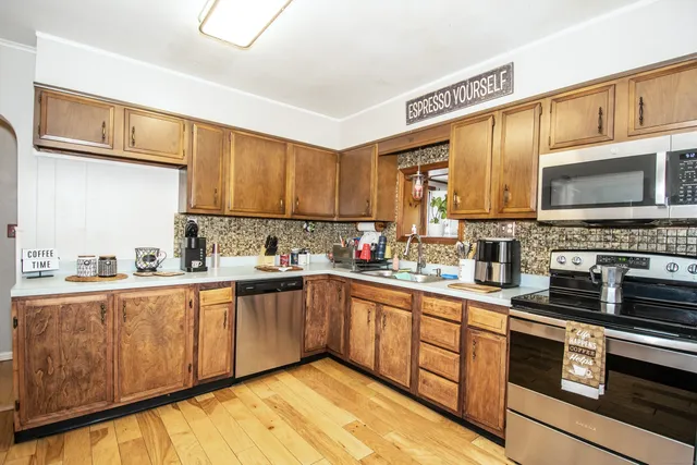 a kitchen with stainless steel appliances a sink cabinets and a stove top oven