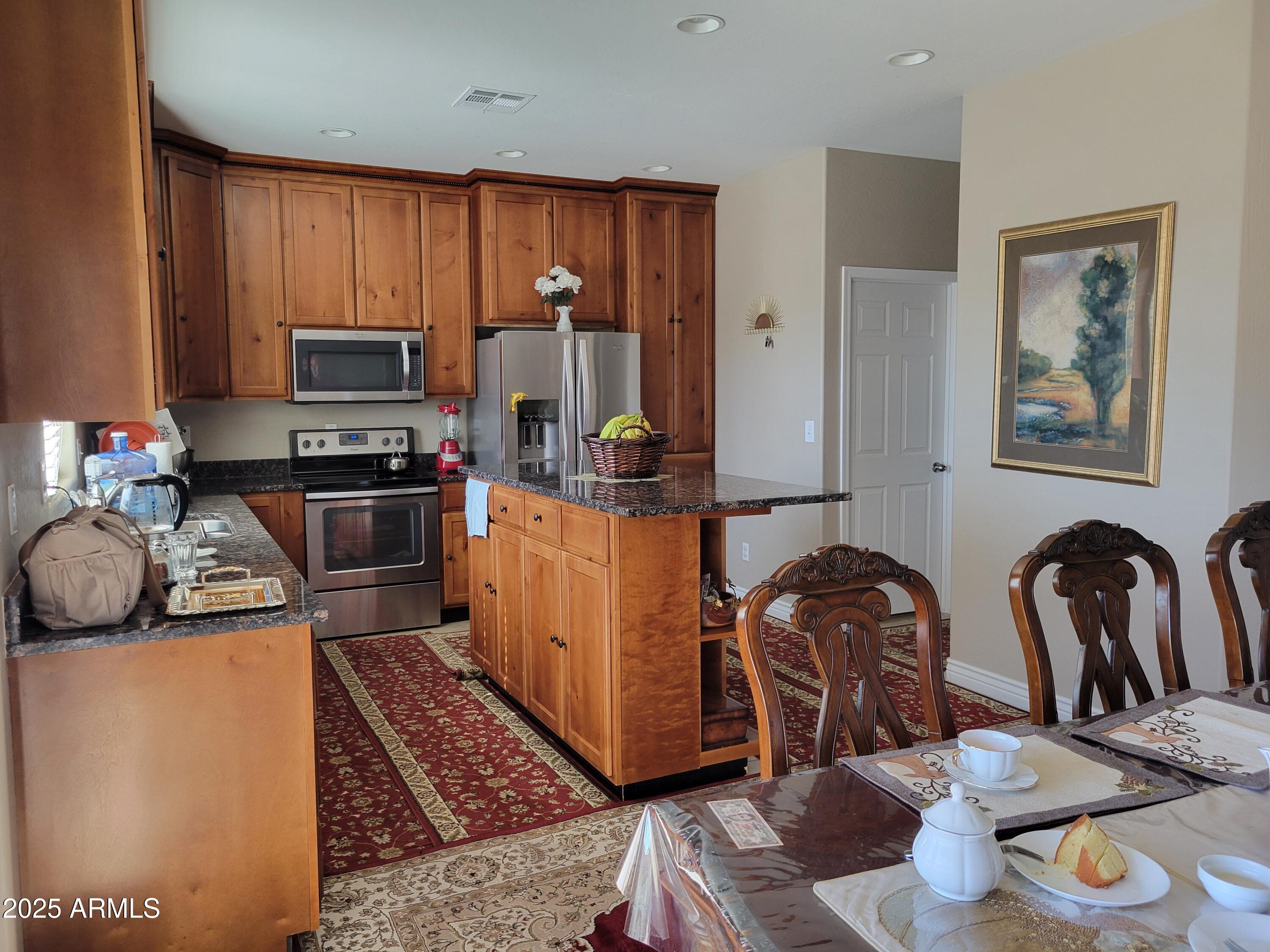 7439 West Wolf Street Phoenix, AZ 85033 - Photo 11 of 21 a kitchen with stainless steel appliances granite countertop a sink stove and refrigerator