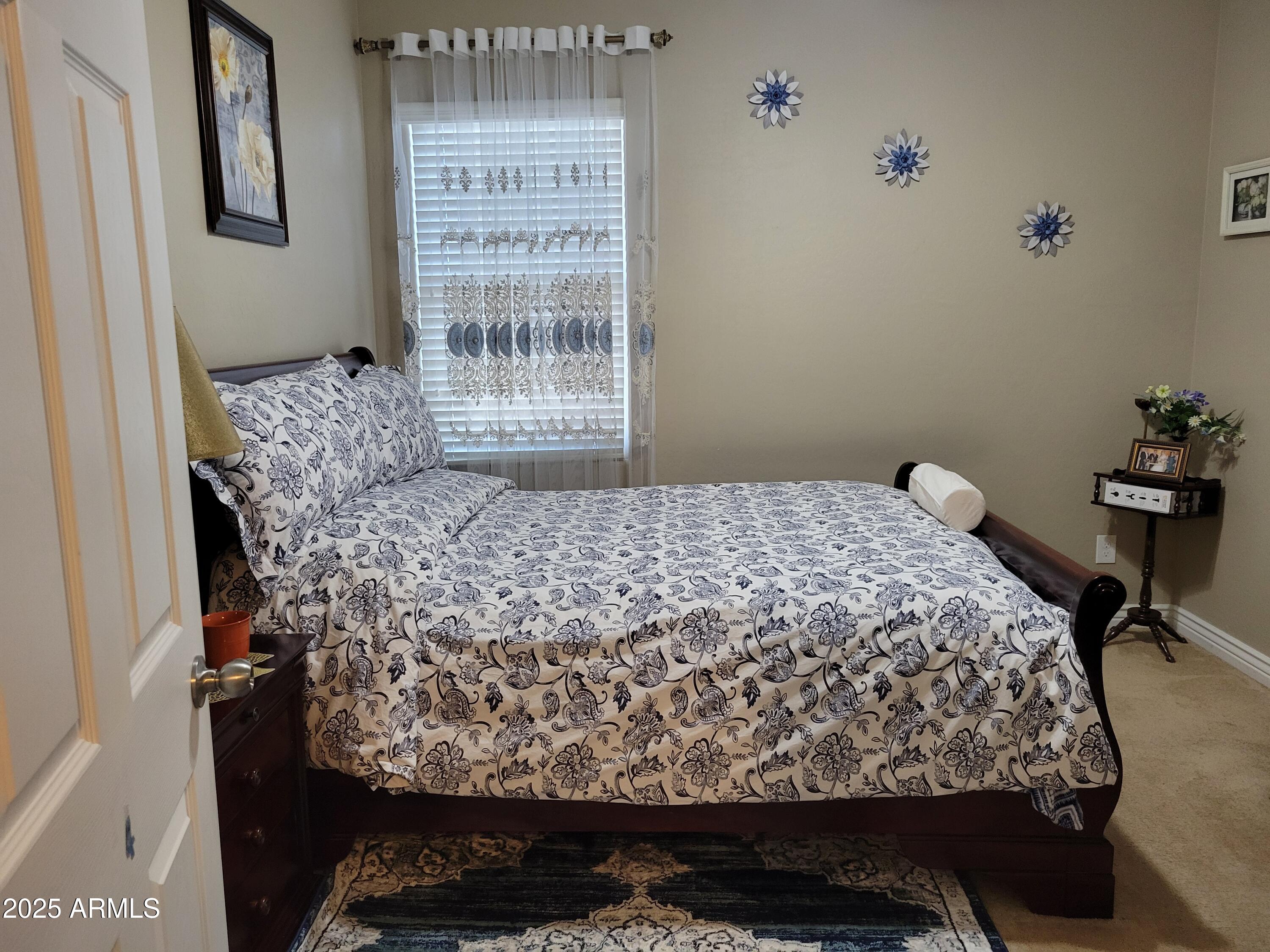 7439 West Wolf Street Phoenix, AZ 85033 - Photo 17 of 21 a bed sitting in a bedroom next to a window