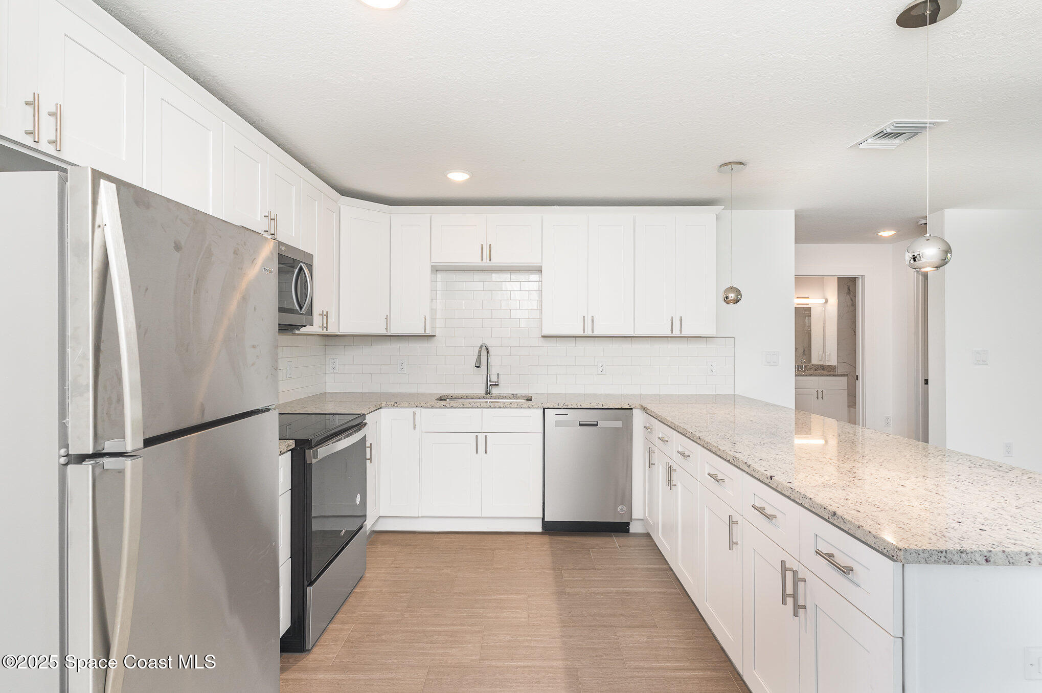 1635 Par Street Northeast, Unit 2103 Palm Bay, FL 32905 - Photo 10 of 36 a kitchen with granite countertop a refrigerator and a sink