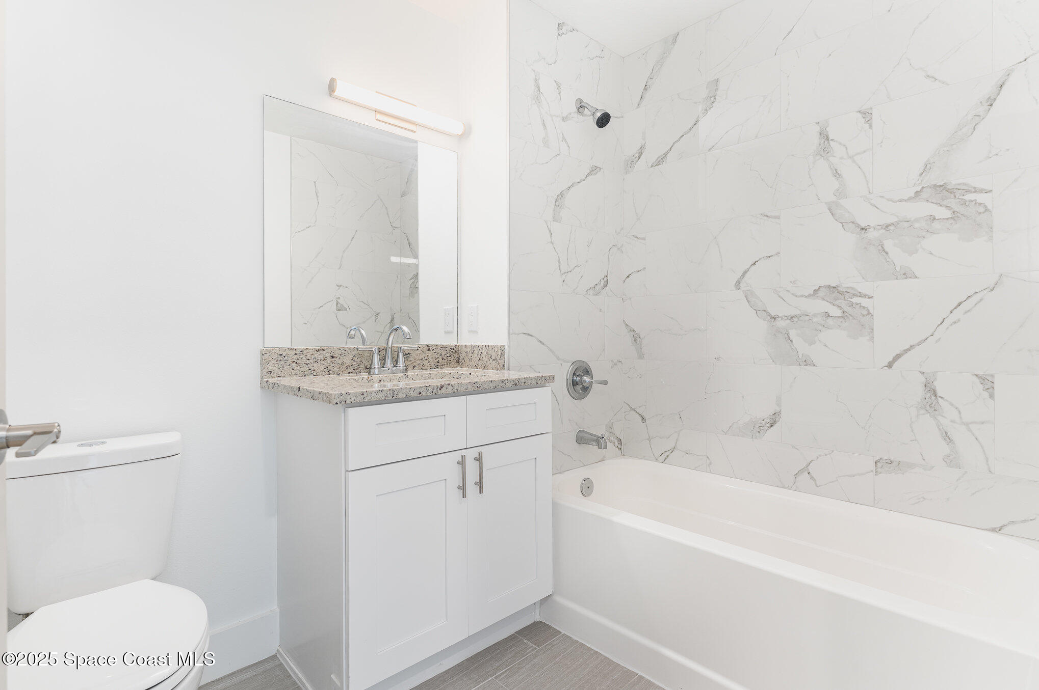 1635 Par Street Northeast, Unit 2103 Palm Bay, FL 32905 - Photo 19 of 36 a bathroom with a granite countertop sink a toilet and bathtub
